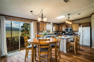 cocina con mesa y sillas y cocina con nevera en Angel Fire Home Sangre de Cristo Mountains View!, en Angel Fire