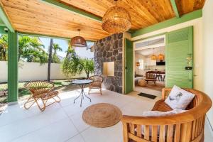 VILLA EMERAUDE - A 200m du magnifique lagon de l'Hermitage à ST GILLES LES BAINS - Villa 3 chambres avec piscine في Saint-Paul: غرفة معيشة بجدران خضراء وسقف خشبي