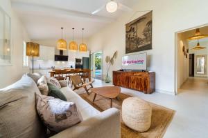 VILLA EMERAUDE - A 200m du magnifique lagon de l'Hermitage à ST GILLES LES BAINS - Villa 3 chambres avec piscine في Saint-Paul: غرفة معيشة فيها أريكة وتلفزيون