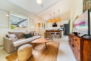 VILLA EMERAUDE - A 200m du magnifique lagon de l'Hermitage à ST GILLES LES BAINS - Villa 3 chambres avec piscine في Saint-Paul: غرفة معيشة مع أريكة وتلفزيون