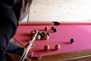 a person playing a game of pool on a pink table at Hôtel Les Roches Fleuries in Cordon