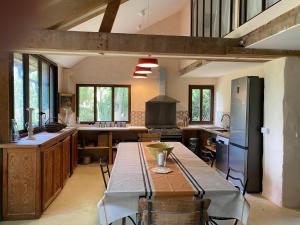 a large kitchen with a table and a stove at Chambres d'hôtes -L'Atelier du Presbytère 