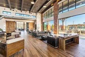 een open woonkamer met veel meubels en ramen bij 1min Delta - Pool & Hot tub - King Bed - Gym - Parking in 214 North Temple Condominium