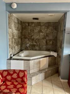 a bath tub in a bathroom with a red chair at Skylark Motel in Chicago