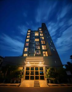 a tall building at night with its lights on at The Elite Residence Dhaka in Dhaka