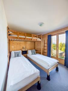 Dos literas en una habitación con ventana. en Grand chalet familial et convivial à La Tzoumaz, en La Tzoumaz
