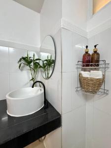 a bathroom with a sink and a mirror at PROpaganda Guest House in Thongsala