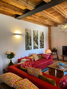 a living room with two red couches and a table at AGRITURISMO MODOLO Belluno Dolomiti in Belluno
