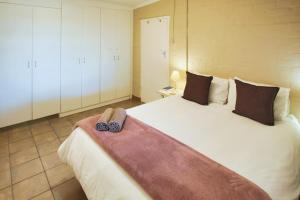 a bedroom with a large bed with two slippers on it at Oppi Stuppi, Langebaan, 4-sleeper in Langebaan