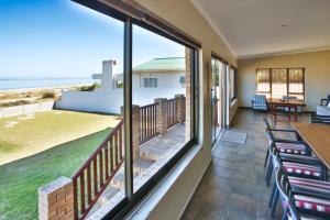 a balcony with chairs and a view of the ocean at Oppi Stuppi, Langebaan, 4-sleeper in Langebaan
