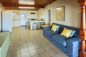 a living room with a blue couch and a kitchen at Oppi Stuppi, Langebaan, 4-sleeper in Langebaan