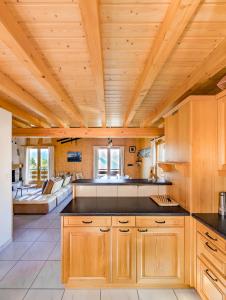 cocina con techos de madera y sala de estar. en Grand chalet familial et convivial à La Tzoumaz, en La Tzoumaz