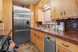 eine Küche mit Edelstahlkühlschrank und Holzschränken in der Unterkunft All in Cabin in Big Bear Lake