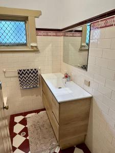 a bathroom with a sink and a mirror at 3BR Guest House near Adelaide CBD Joslin 5070 in Evandale