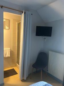 a bedroom with a blue chair and a television at Chez Sam & So'6 