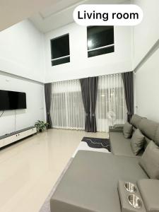 a living room with a couch and a tv at Monday Guesthouse2 Hatyai in Hat Yai