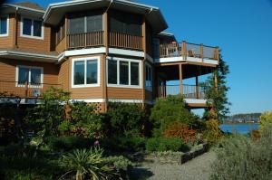 a large house with balconies on a lake at Family Vacation Home - Stunning Views across Salt Pond in Bethany Beach