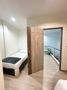 a bedroom with a bed and a door with a balcony at Monday Guesthouse2 Hatyai in Hat Yai