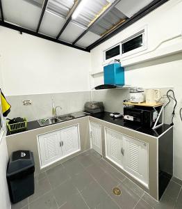 a kitchen with white cabinets and a sink at Monday Guesthouse2 Hatyai in Hat Yai