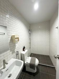 a white bathroom with a toilet and a sink at Monday Guesthouse2 Hatyai in Hat Yai