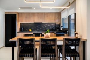 a kitchen with a large wooden table and chairs at Majo Luxury Villas Panoramic Sea View Retreat with Heated Private Pools & Gym & Sauna in Agia Pelagia +63 photos