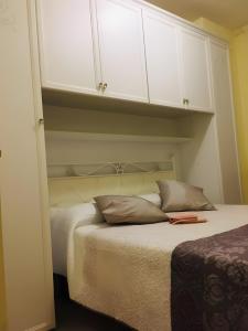 1 dormitorio con 1 cama con armarios blancos en Rosato 14-balcone Sul Mare, en Stazione Marittima