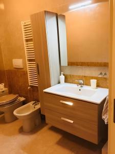 Un baño con un lavabo blanco y un inodoro. en Rosato 14-balcone Sul Mare, en Stazione Marittima