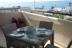 una mesa con platos y vasos en el balcón en Rosato 14-balcone Sul Mare, en Stazione Marittima