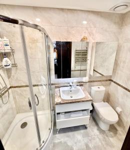a bathroom with a toilet and a sink and a shower at The All-in-One Loft in Ulaanbaatar