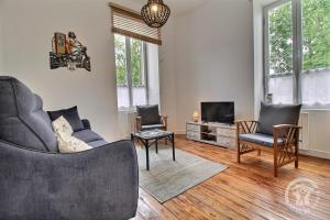 a living room with a couch and chairs and a tv at Chez sylvie in Paimpol