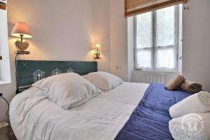 a bedroom with a large white bed with a blue blanket at Chez sylvie in Paimpol