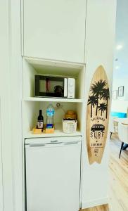 a white refrigerator in a kitchen with a surfboard at Water Vibes Porto by MyMoradia in Porto
