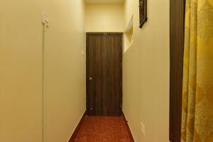 a hallway with a wooden door in a room at FabHotel Shivalya in Kolkata