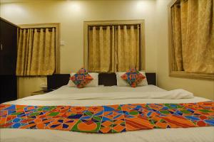 a bedroom with a large bed with a colorful comforter at FabHotel Shivalya in Kolkata +16 photos