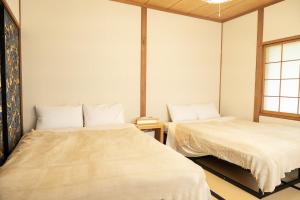 a room with two beds and a window at The Sake Kura villa in Hakuba