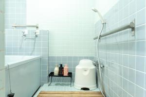 a bathroom with a shower with a toilet and a sink at The Sake Kura villa in Hakuba +30 photos