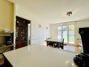 a kitchen and dining room with a table at Le Petit Podium Cozy Ground Floor in Carentan +8 photos