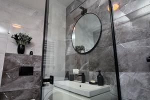 アウグストゥフにあるApartament CzarnyBlaskの洗面台と鏡のあるバスルーム +21枚の写真