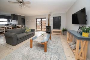 a living room with a couch and a table at 8 Vineyard in Somerset West