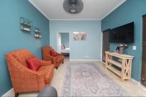 a living room with two chairs and a table at 8 Vineyard in Somerset West