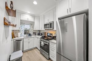 a kitchen with white cabinets and a stainless steel refrigerator at - Free Parking & 5-Min Walk To Metro - Book Now! in Alexandria