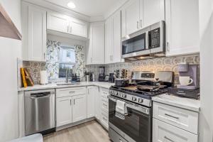 a kitchen with white cabinets and a stove top oven at - 5-Min Walk To Metro - Free Prking - Escape in Alexandria +19 photos