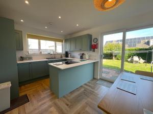 een keuken met groene kasten en een groot raam bij Nº Twenty Spottiswoode in St Andrews