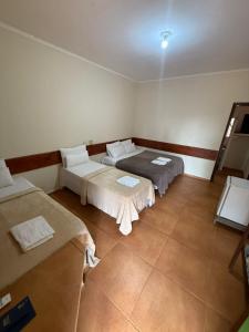 a room with two beds and a mirror in it at Pousada cores in Olímpia +8 photos