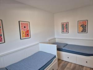 バート・ヴィルドゥンゲンにあるHaus am Burgwegのベッドルーム1室(ベッド2台付)が備わります。壁には絵画が飾られています。