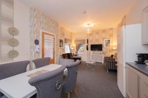 a kitchen and living room with a table and chairs at The Lodge House Callander in Callander