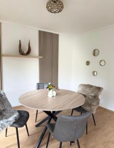 Un comedor con mesa y sillas de madera. en Heidezauber für 2-4 Personen, en Hanstedt
