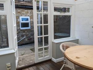 a patio door with a table and a window at Cosy Cottage in beautiful Masham in Masham