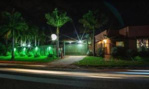 a house with green lights on a street at night at Pousada cores in Olímpia