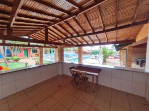 a patio with a wooden table and a wooden roof at Pousada cores in Olímpia
